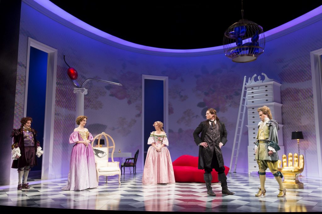 The cast of The School For Lies featuring Alexander Dodge’s lush aqua blue parlor setting.