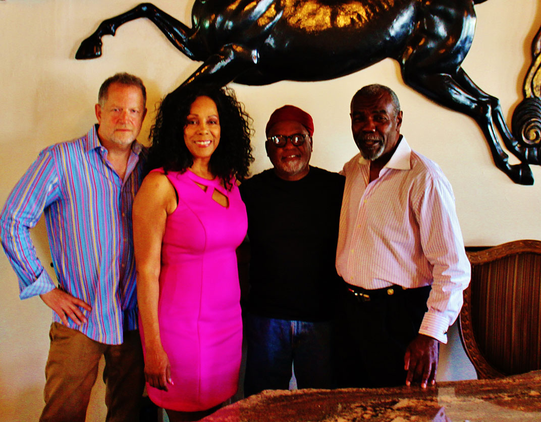 Band members Michael Ross, vocalist Katt Hefner and vocal percussionist Ed Johnson join the Host Elihu Braveboy take a moment before closing for a group picture under the recycled fiberglass stallion.